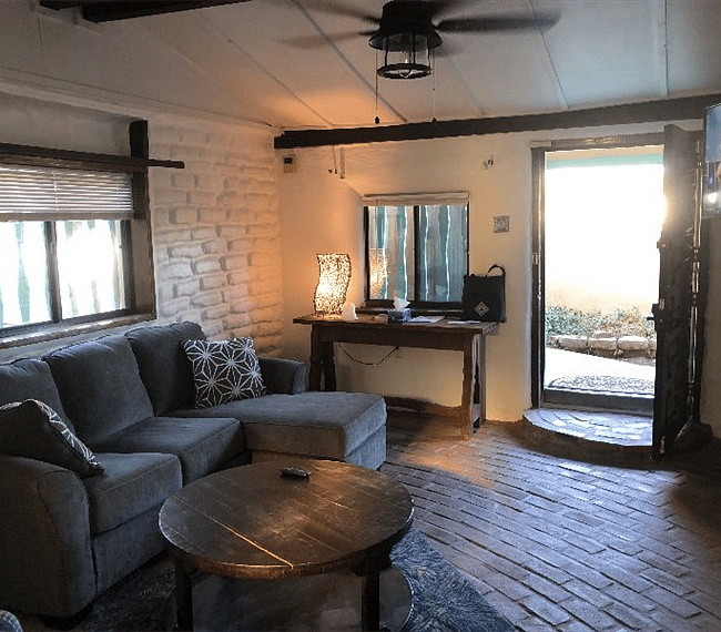 Spacious living room with sectional L-Shape sofa, stuffed aditional chair, tables, mirror & TV