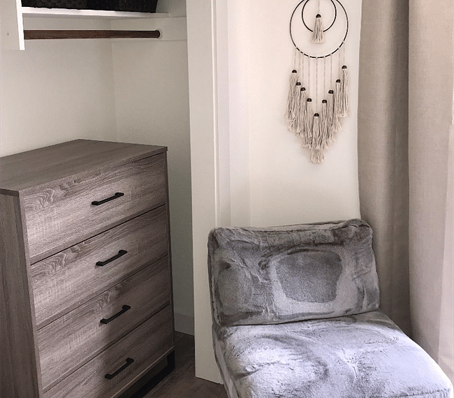 Master bedroom with queen sized bed, drawer, aditional chair & TV