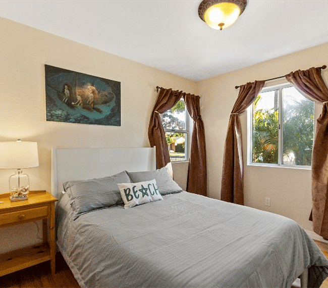 2nd bedroom with retro full size bed, night stand, lamp and beautiful paintings