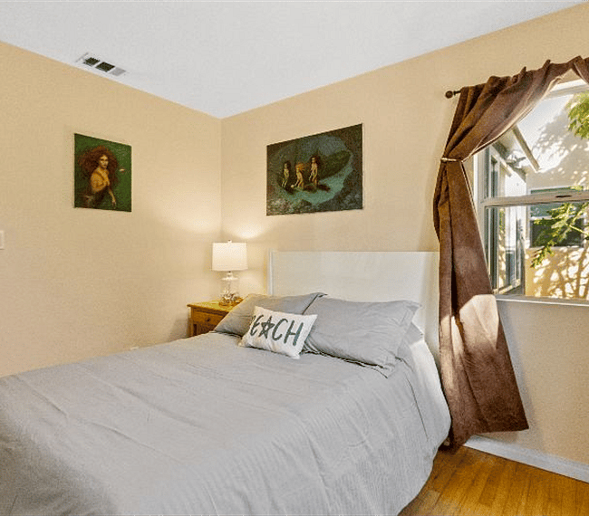 2nd bedroom with retro full size bed, night stand, lamp and beautiful paintings