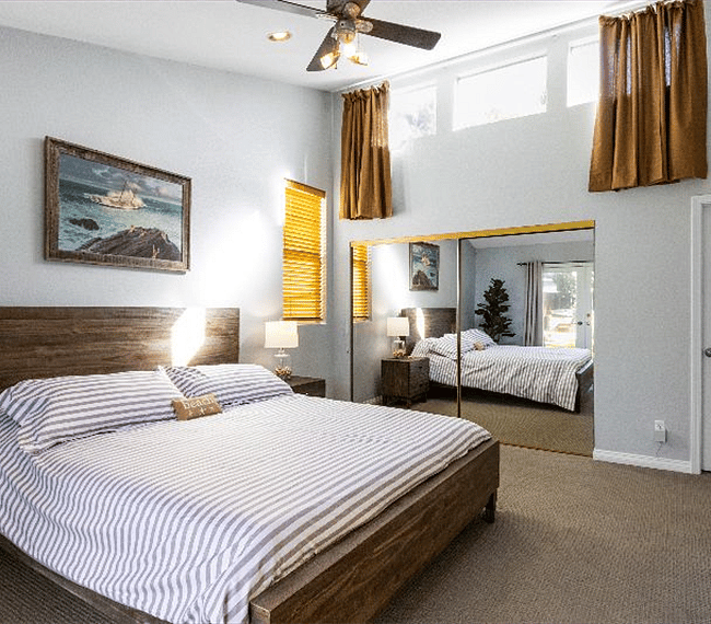 3rd bedroom with retro king size bed, night stand, lamp, wardrobe, beautiful paintings & direct access outdoors