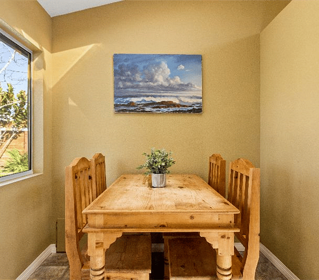 Rectangle light wooden table with 4 spots, right next to the kitchen
