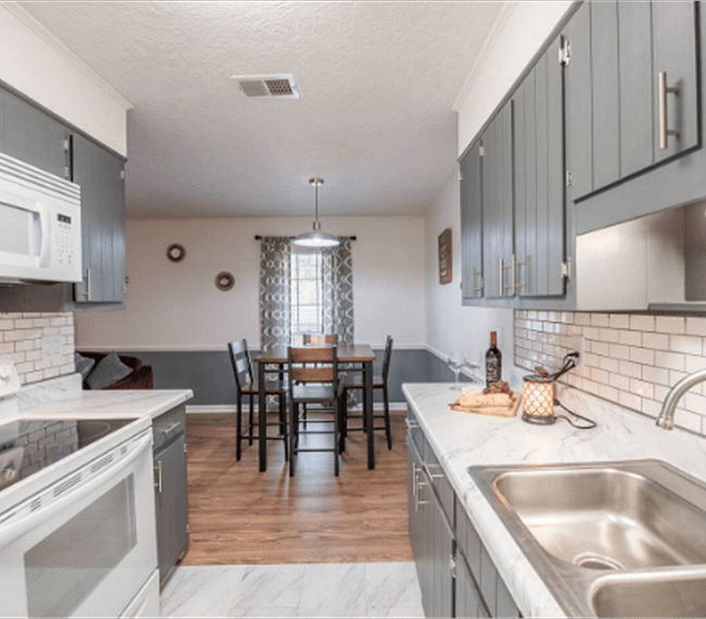 Dining area with squared table of 4 spots, right next to the kitchen