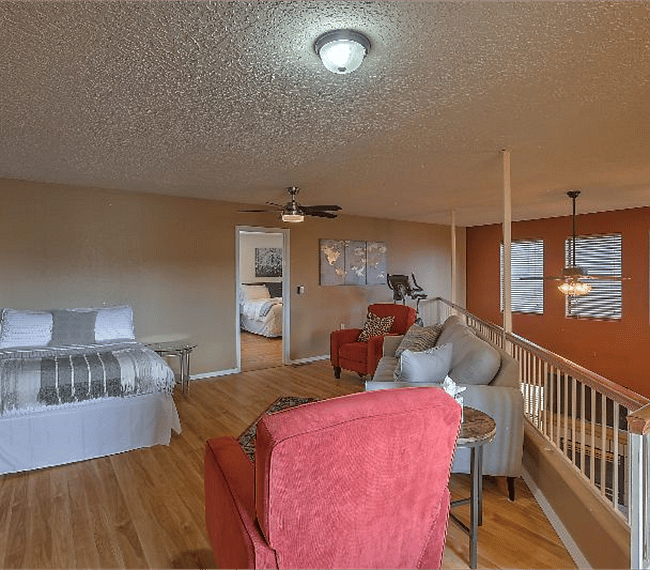 2nd floor living room with 1 lawson style sofa, 2 aditional charis & 1 bed