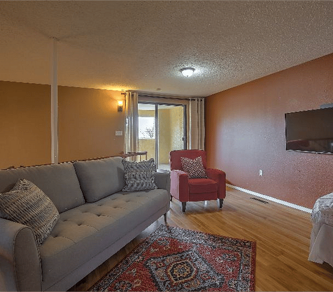 2nd floor living room with 1 lawson style sofa, 2 aditional charis & 1 bed