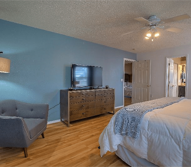 1st masters bedroom with queen sized bed, lovely night stands, wide drawers, TV & a stuffed sofa