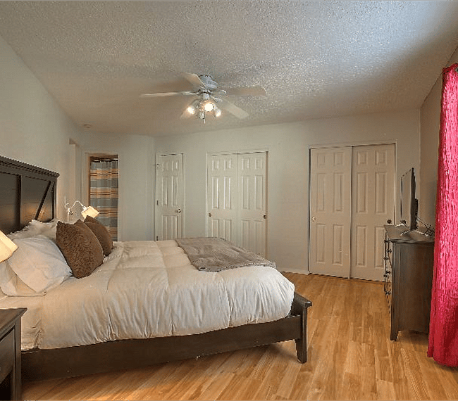 2nd masters bedroom with king sized platform bed, drawers, TV, wide wardrobe & personal bathroom