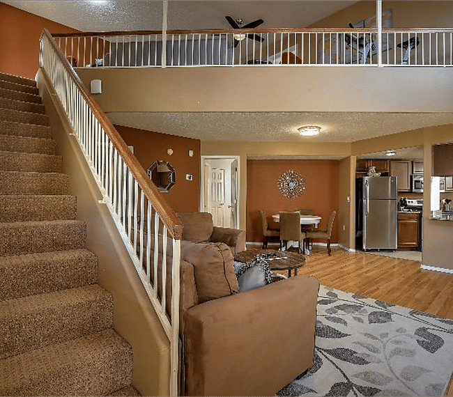 Spacious living room with 2 lawson style sofa, fireplace, carpet, flat table & dining area