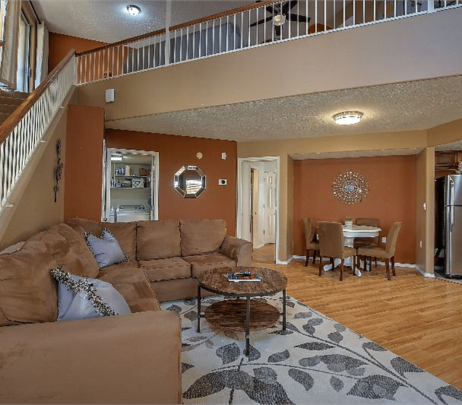 Spacious living room with 2 lawson style sofa, fireplace, carpet, flat table & dining area