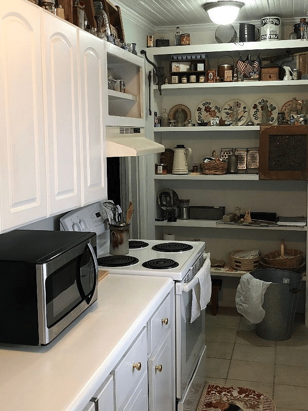A fully equipped kitchen with antiques displayed above cabinets, we call this our Cracker Barrel inspired kitchen.