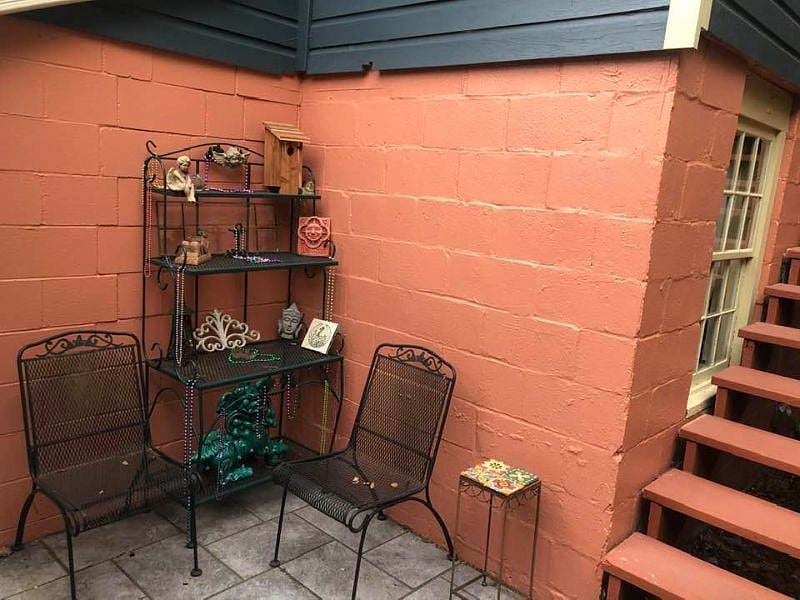 Patio with conversation space at base of stairway leading to the apartment.