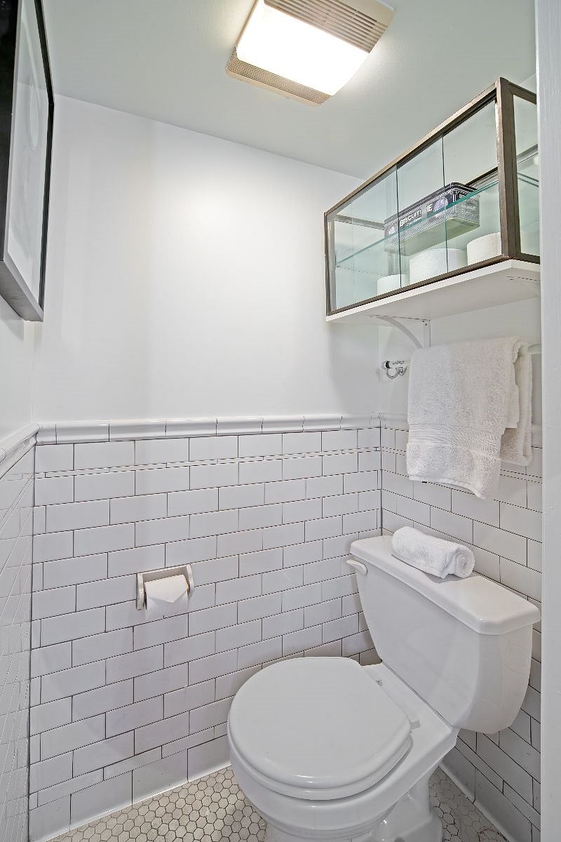 Separate tile lined water closet with exhaust fan,