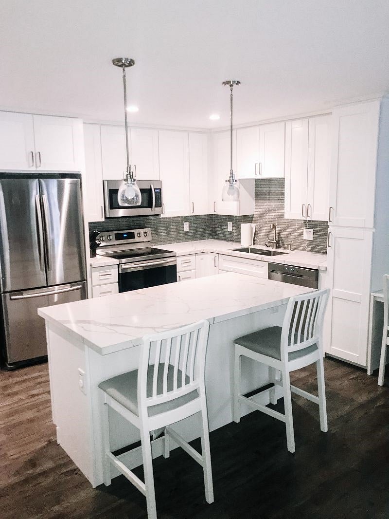 Fully equipped kitchen with all essential implements included, such as stove, microwave and fridge, island bench and 2 high chairs