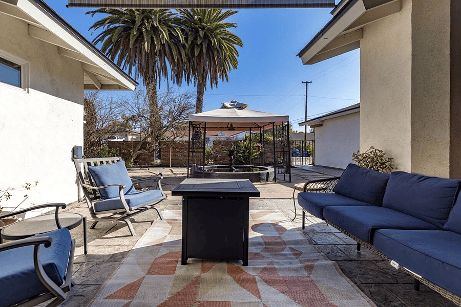 Front patio includes fire pit and pond with fountain
