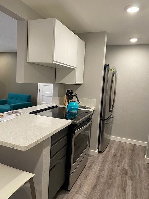 Kitchen features full-size fridge, microwave, pots and pans, dishes. 