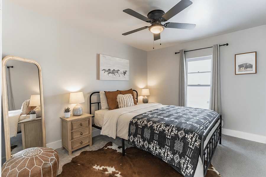 Rest easy in the spacious primary bedroom featuring a queen bed, plush bedding, and calming natural textures.