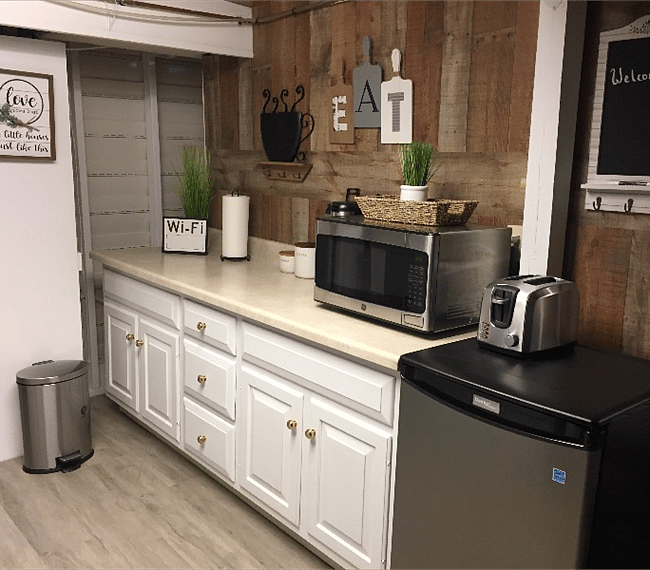 Kitchenette with small refrigerator, microwave and coffee maker. Full size washer and dryer are directly opposite.
