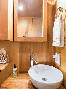 Bathroom sink with a live edge wooden countertop.