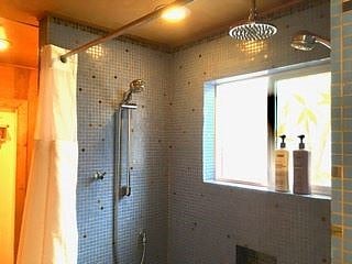 Bathroom has a heated tile floor and three shower heads.