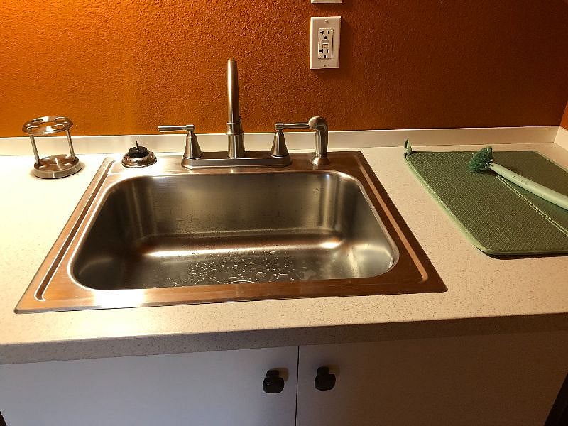 Kitchen sink for washing dishes is located in the bathroom