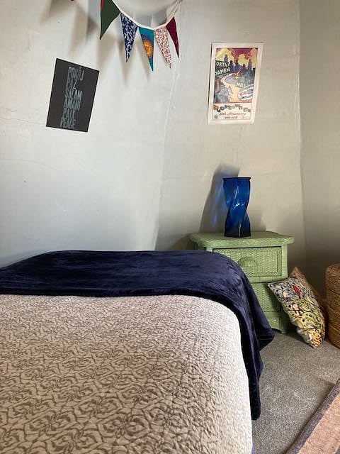 Small bedroom in turret of house. Cozy with twin bed. A curtain works as the door.