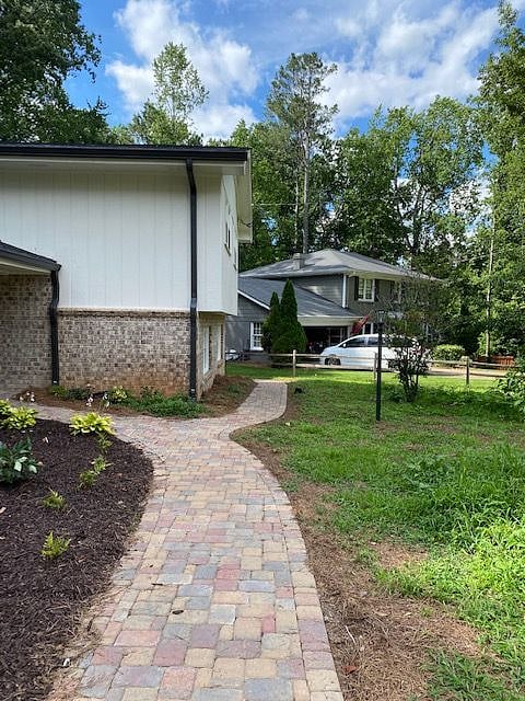 Lighted walkway continues to the right side of the house to private  entrance