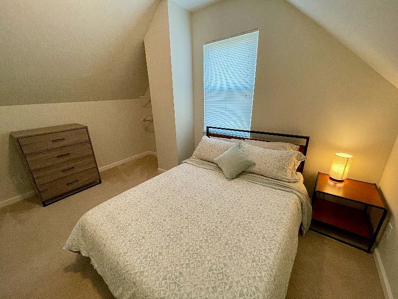 The first upstairs bedroom is cozy and spacious with a queen bed.