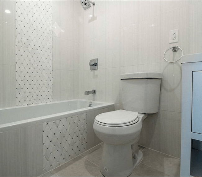 Fully tiled family bathroom with combined bath and shower