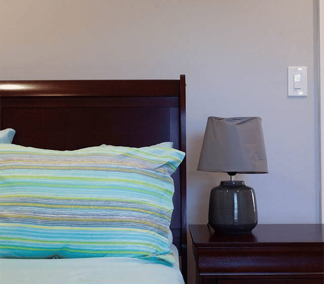 Stylish and ample bedroom with a nightstand and lamp