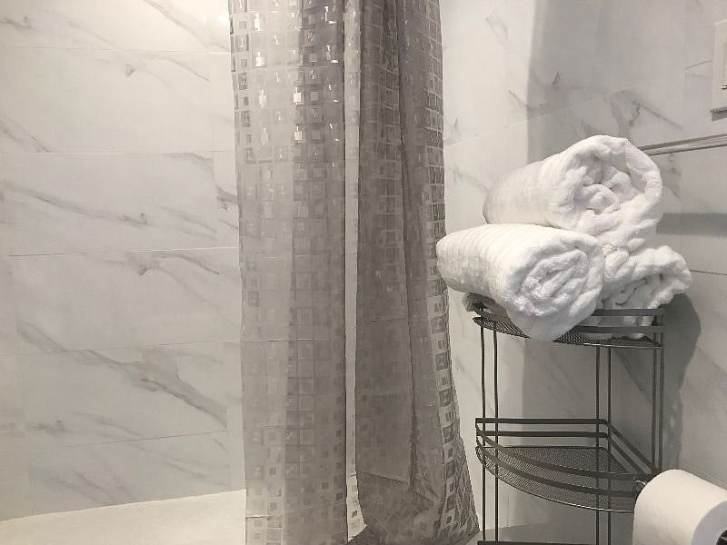 Fully tiled bathroom with shower and bathware 