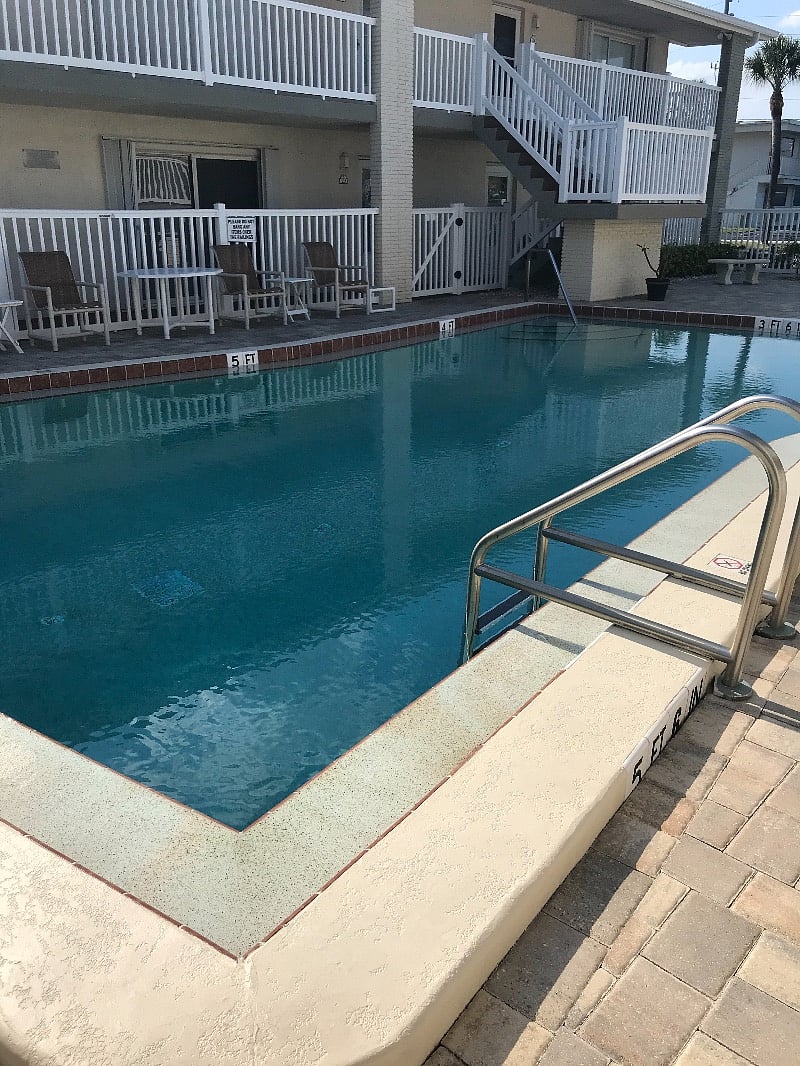 Heated swimming pool with seating areas and a grill