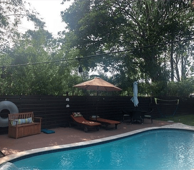 Lovely backyard with lounge chairs, an outdoor umbrella, and hammock