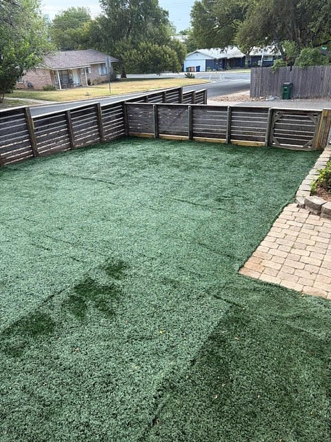 Newly installed artificial turf in front fenced yard