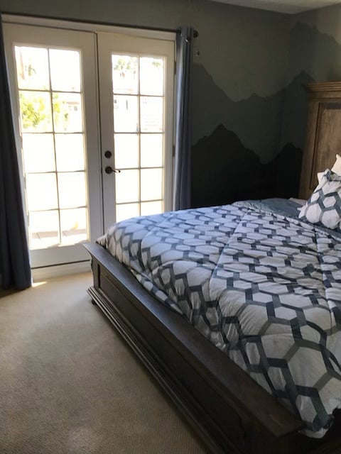 The upstairs guest bedroom has a king bed and French doors onto a private deck