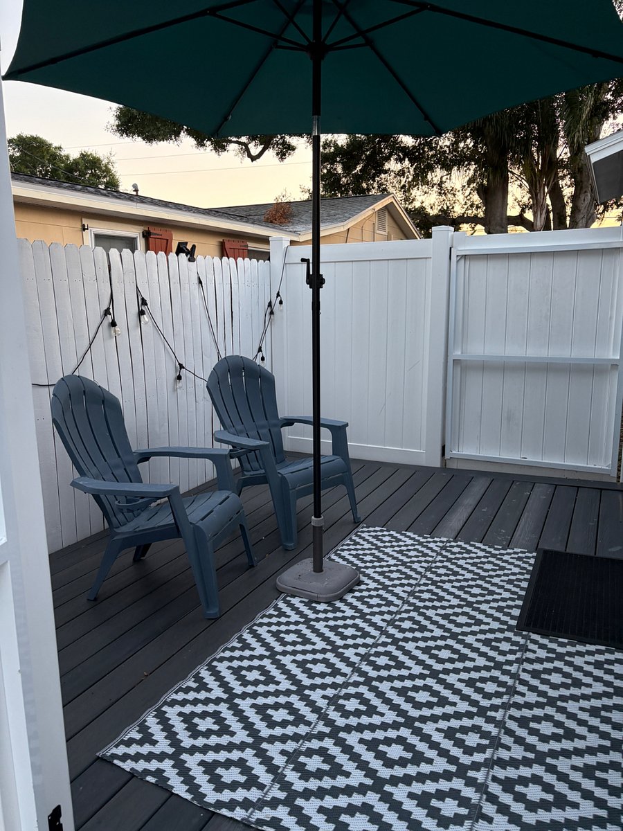 Secure, private patio, with 2 chairs and bistro lights.