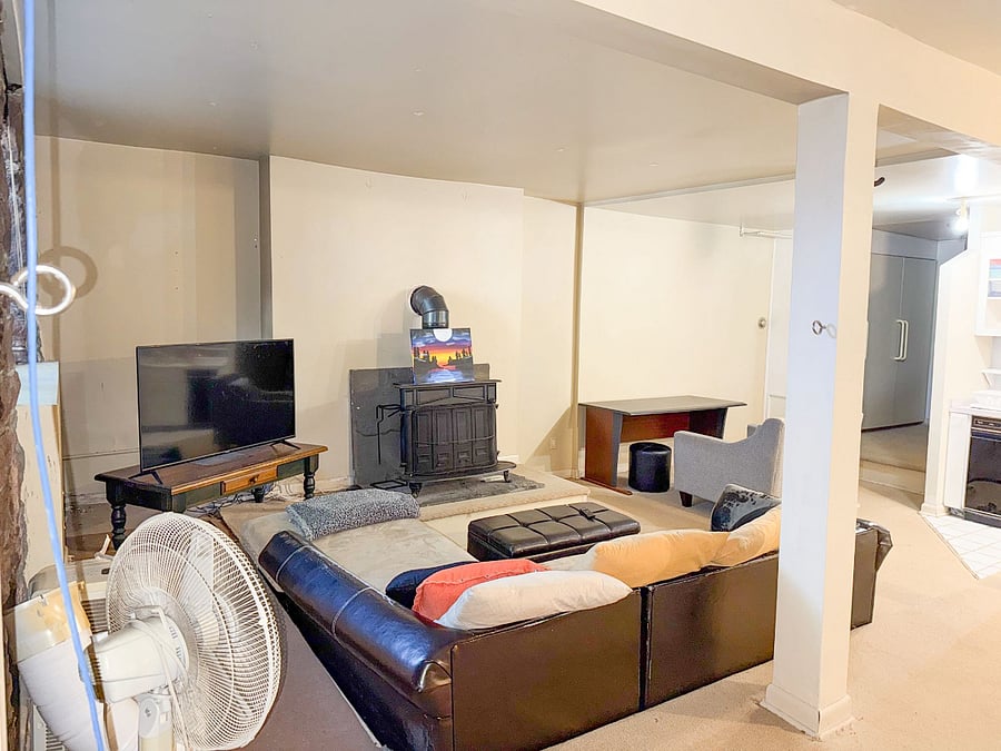 Sunken living area with L shape couch, TV, plush chair and desk