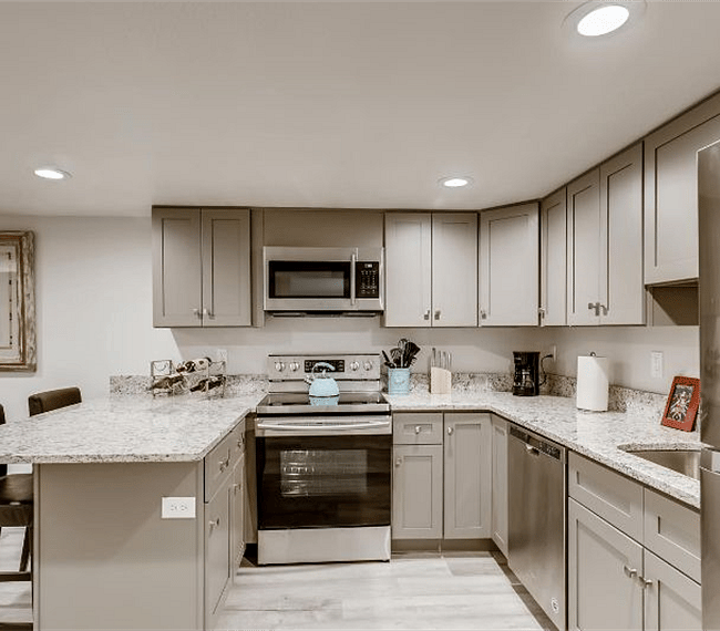 Open kitchen/bar/dining room floor plan with hardwood floors, granite countertops and stainless steel appliances.
