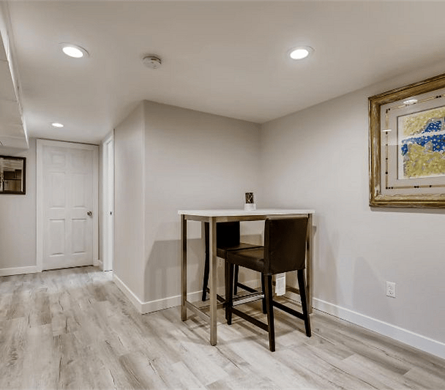 Open kitchen/bar/dining room floor plan with hardwood floors, granite countertops and stainless steel appliances.