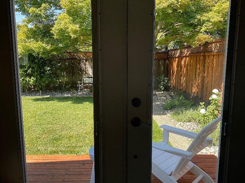 French double doors open to landscaped yard.