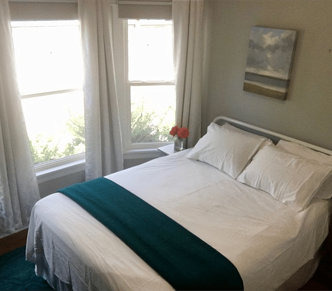 First bedroom with bay windows (and blackout shades); queen bed