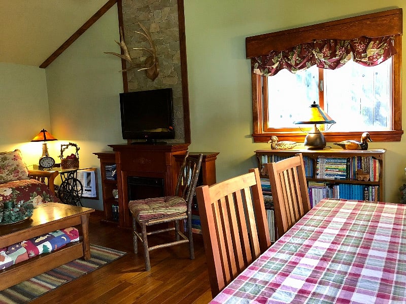 Across from the living/sleeping area is a craftsman style table with chairs, two rustic wall sconces and WiFi/Ethernet connection.
