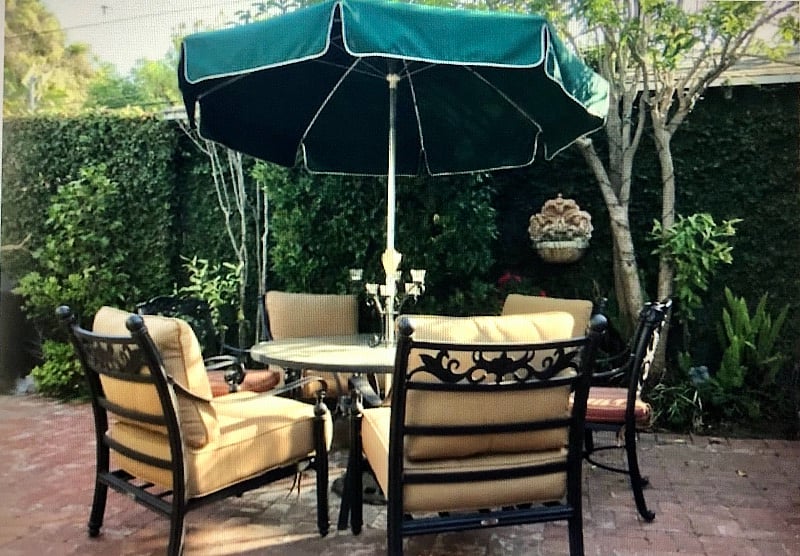 This cast aluminum patio table set with umbrella is outfitted with deep chair cushions to seat six people comfortably for "al fresco" dining!