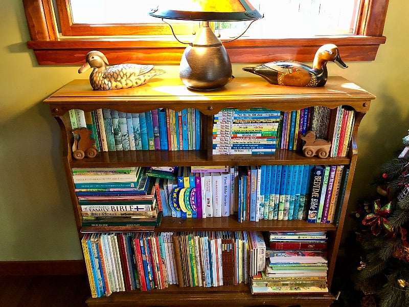 This solid wood vintage bookcase contains a collection of classic children's literature, creating a small, whimsical library nook.