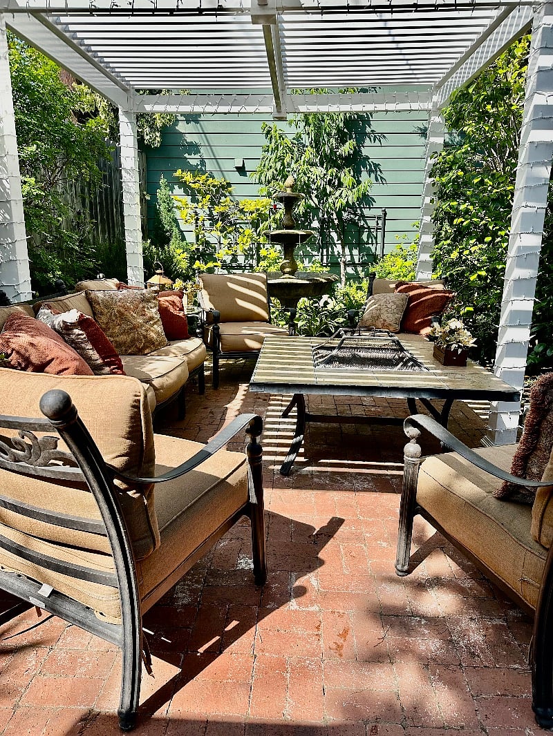 Just outside the Cabin entrance is a filtered sunlight patio with ample seating, mature foliage and a gurgling fountain, creating an additional outdoor living space.