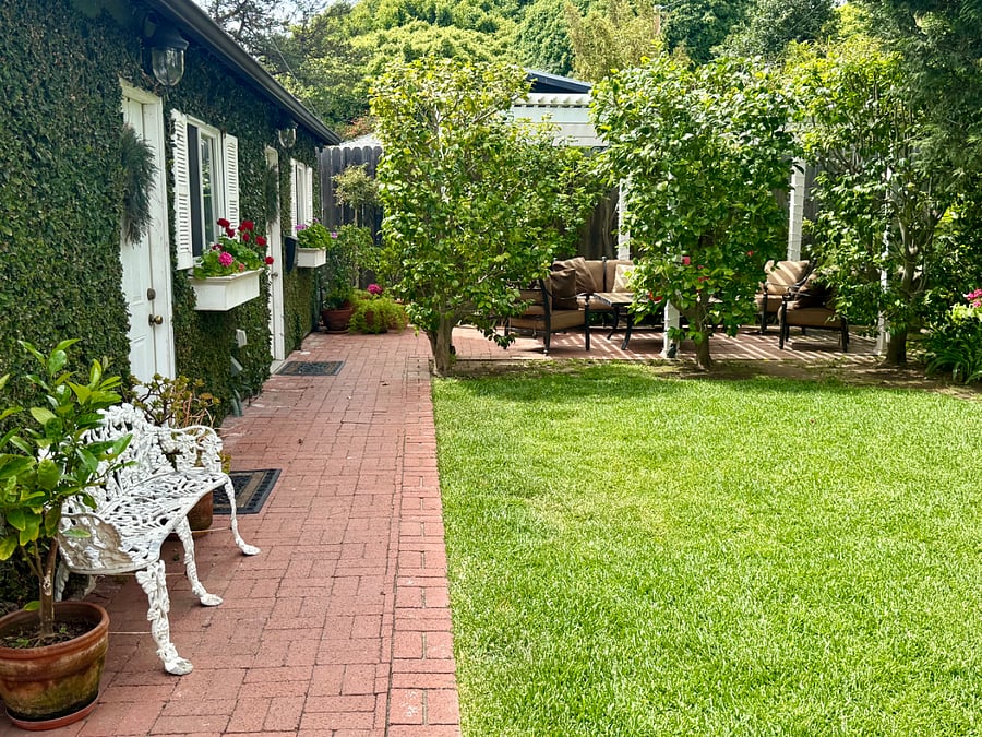 The charming brick pathway continues to lead you through the spacious backyard lawn to your private studio guesthouse and beautiful patio!