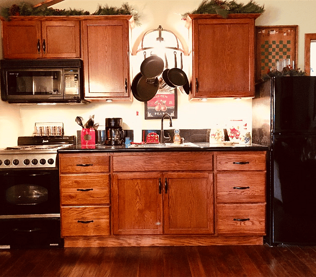 This efficient kitchen features redwood finished cabinets, refrigerator with separate freezer, and electric stove, plus a microwave/convection oven.