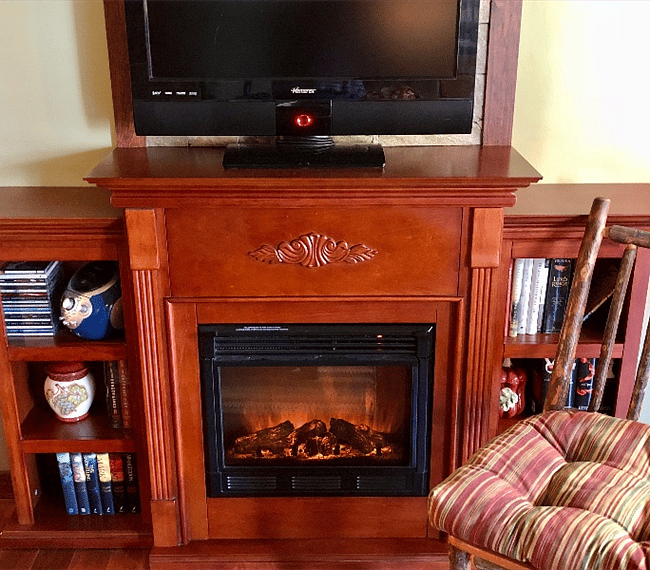 An electric fireplace adds warm coziness to our Cabin in the winter, while a ceiling fan and air conditioning unit keep it cool and breezy in the summer!