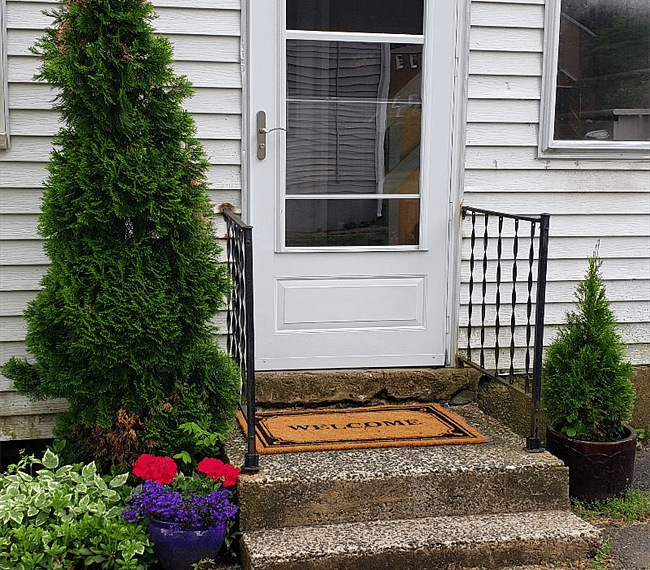 Side/main entrance off the driveway for the whole house. Porched stairwell leads to each individual private apartment all with private entrances.
