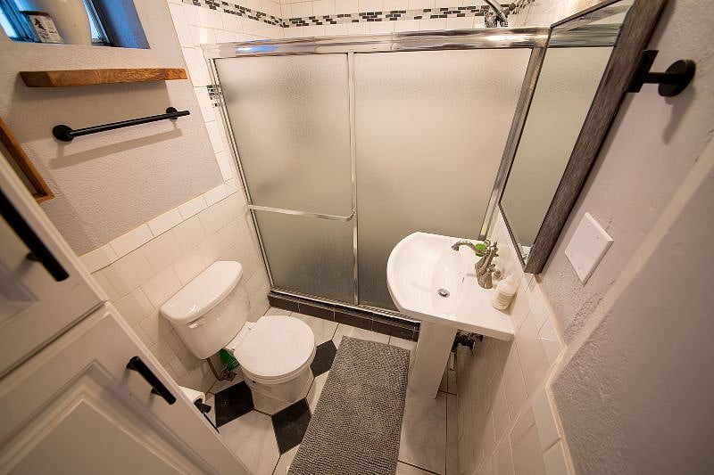 Small bathroom with walk in shower (and shower wand) tons of storage for toiletries and towels.