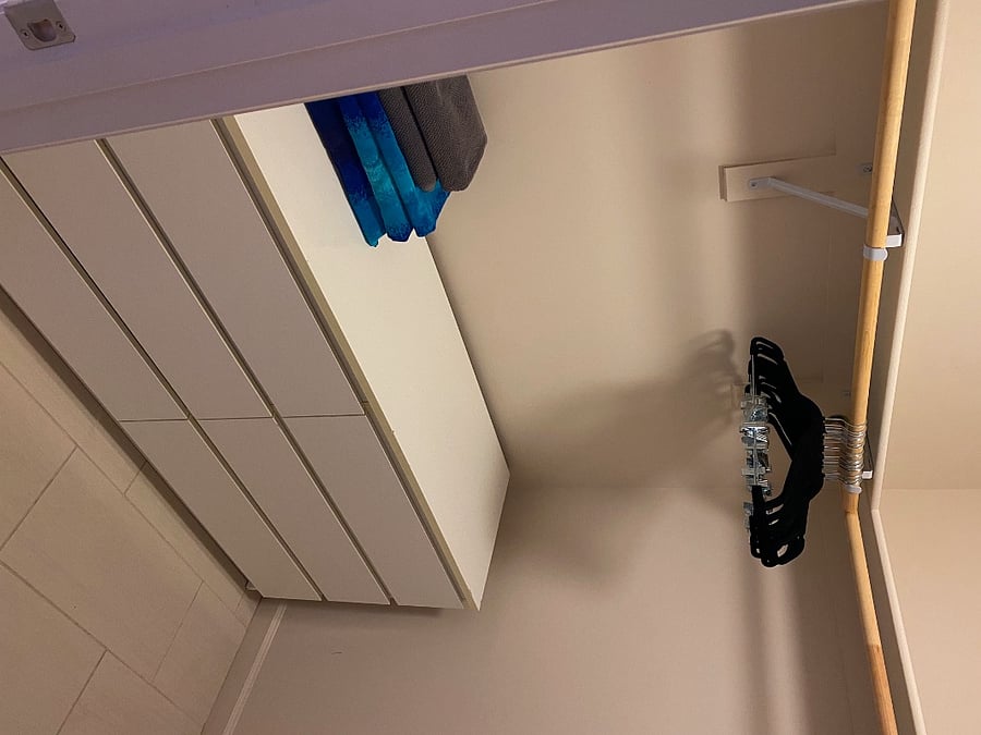 Walk in closet with 6 drawer dresser, hangers, ironing board, iron and length full mirror